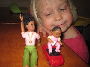 My daughter, age 3, adoringly playing with her doll house figures